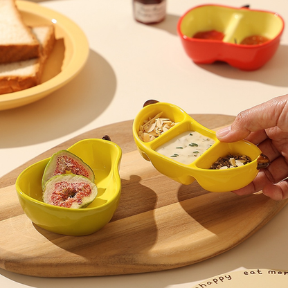 A ceramic fruit-shaped dipping dish - with a bright yellow and red design.