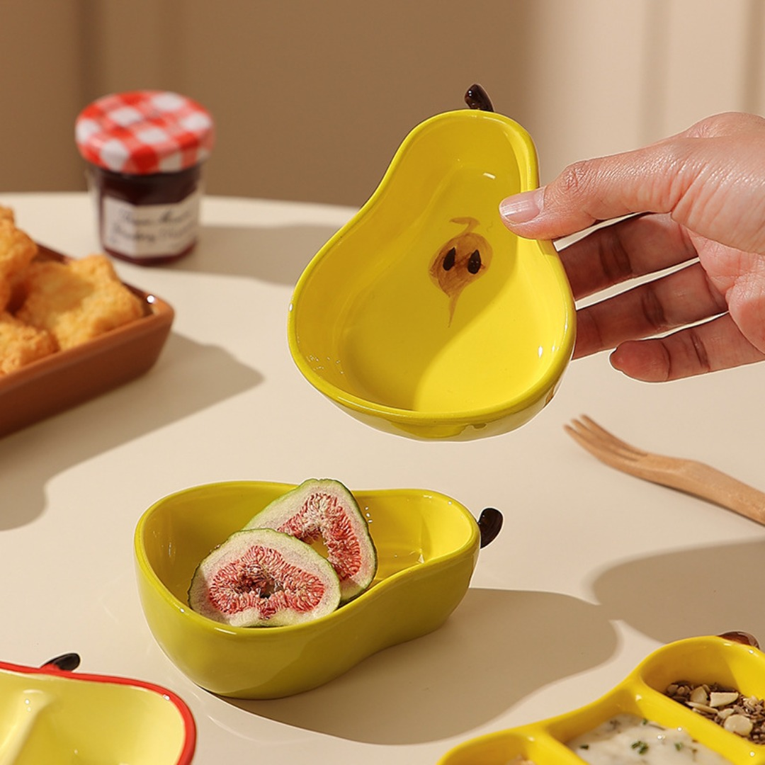 A ceramic fruit-shaped dipping dish - with a bright yellow and red design.