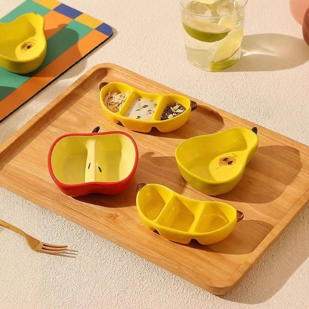 A ceramic fruit-shaped dipping dish - with a bright yellow and red design.